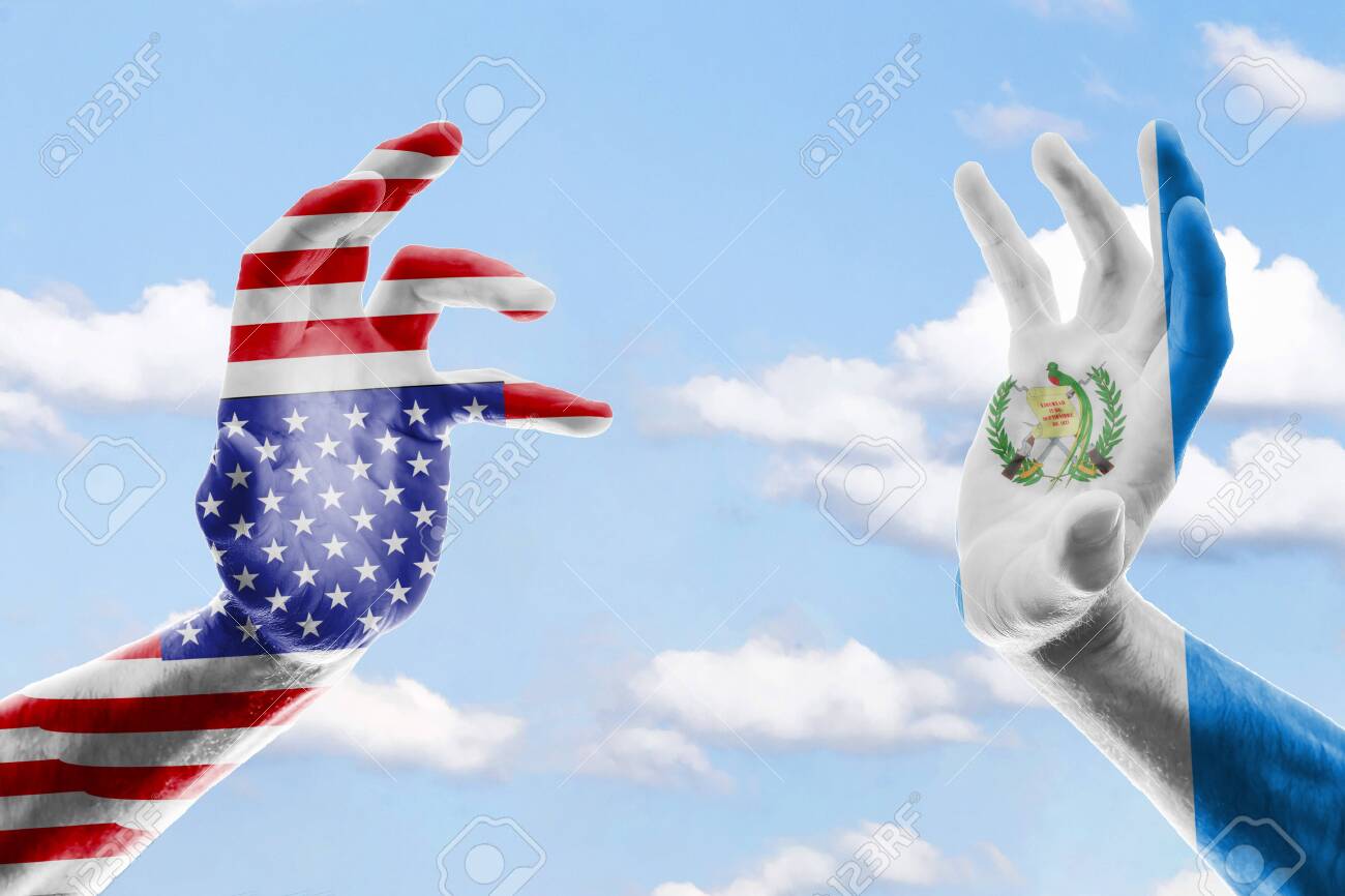 Two hands of a man in the colors of the flags of the USA and Guatemala
